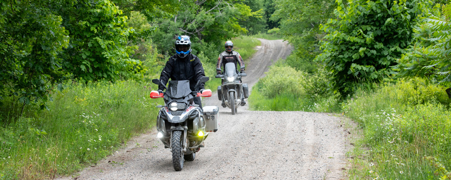 Two adventure motorcycles on a twisty gravel road.